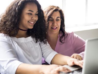 Mom and student look at computer.